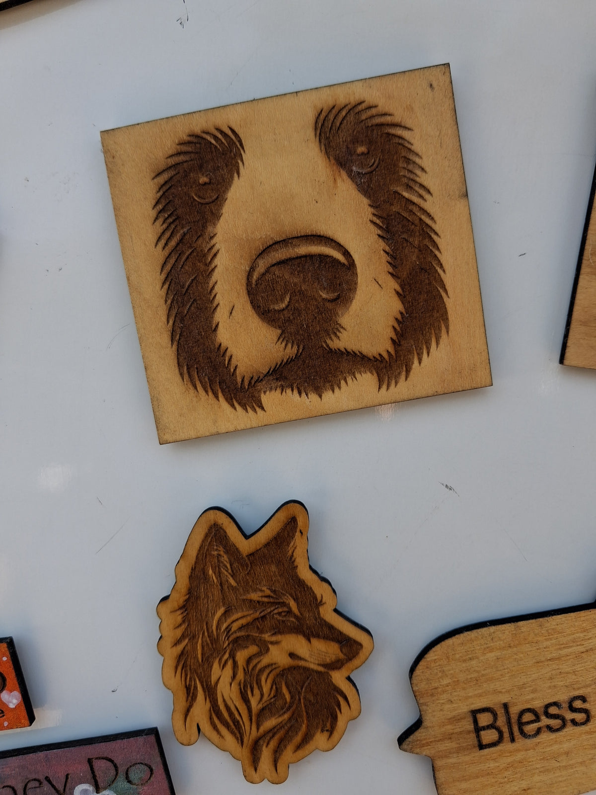 Wood fridge magnets featuring a large dog-face print and a smaller wolf-head cutout