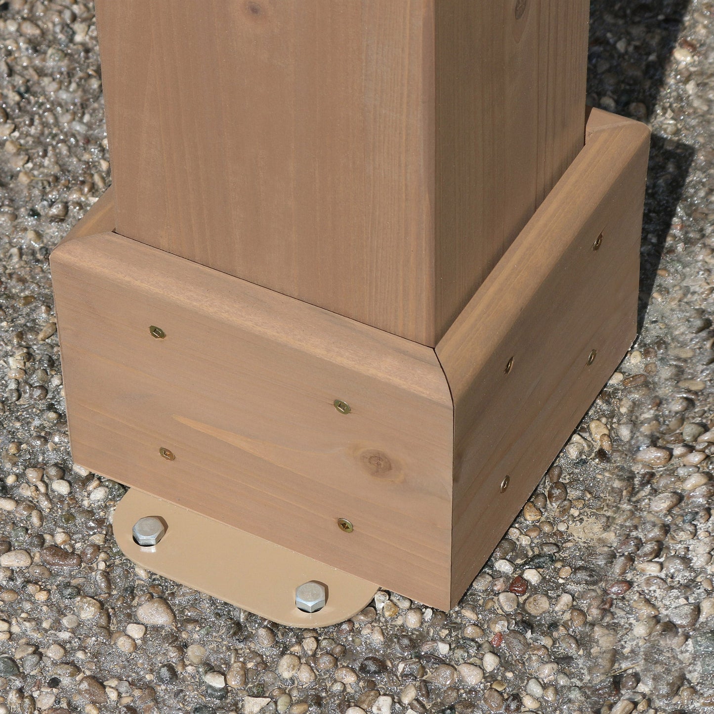 Wood pergola post base with metal anchors on gravel surface