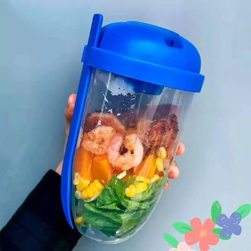 Blue salad shaker cup with dressing container and built-in fork, filled with salad.