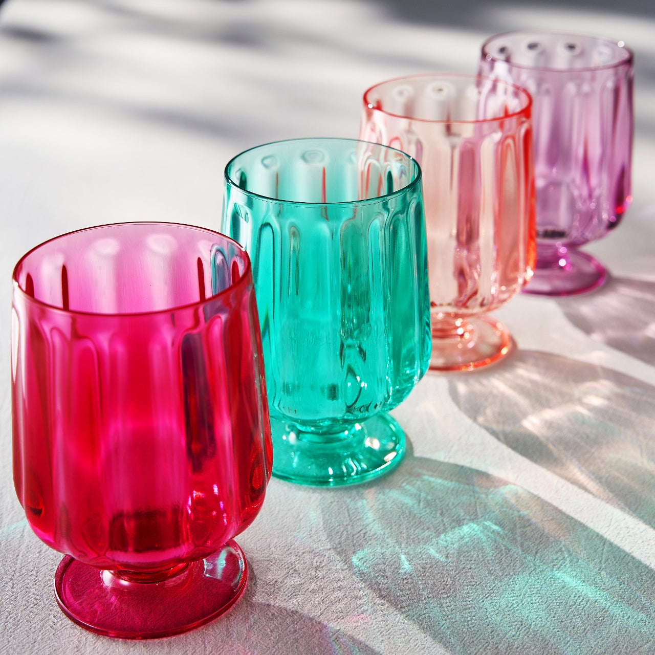 Assorted acrylic stemmed wine goblets in pink, teal, and purple