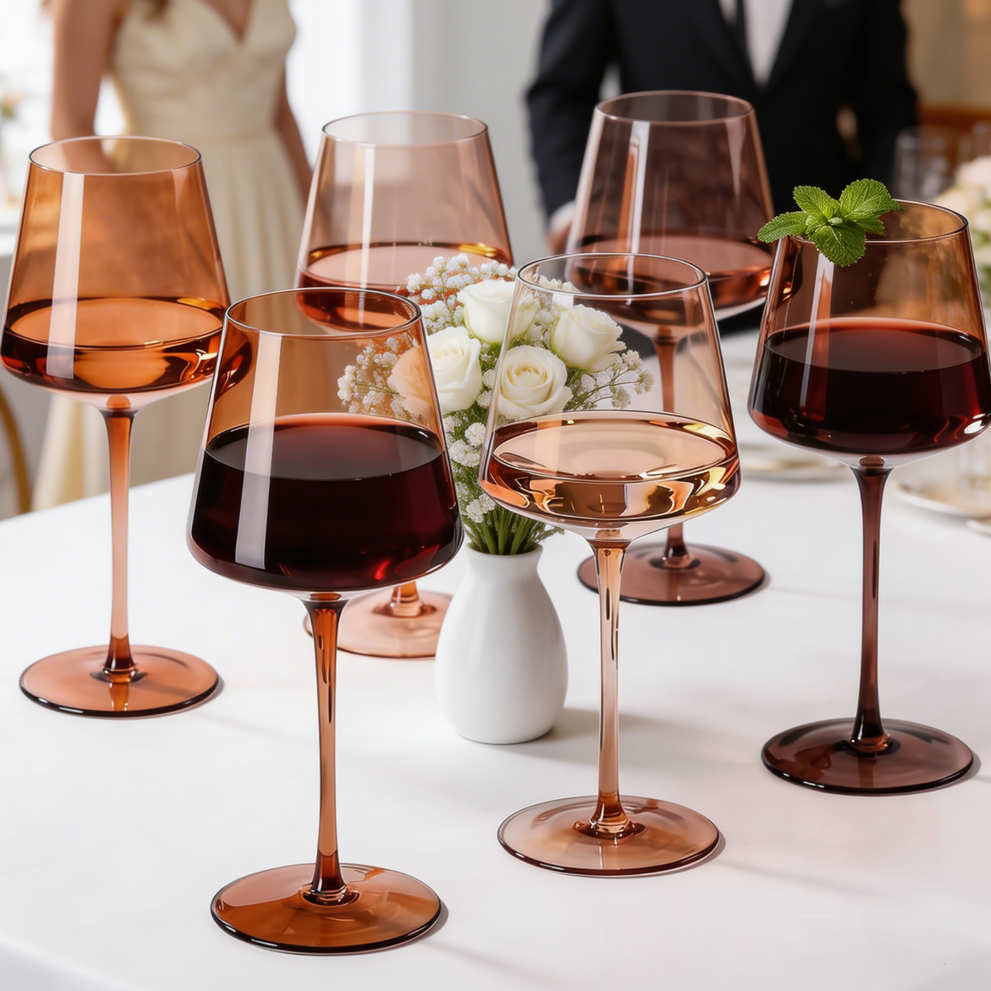 Brown-tinted wine glasses with tall stems arranged around a floral centerpiece