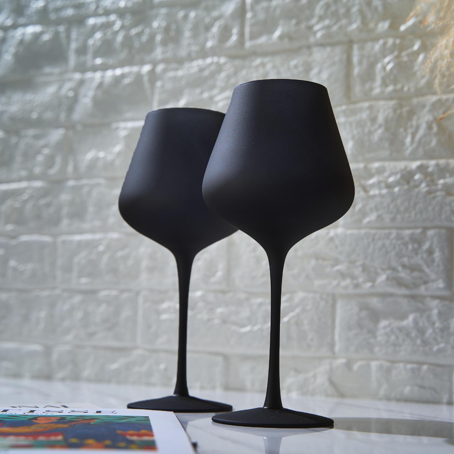 Set of 2 stemmed wine glasses, dark matte finish, close-up tapered bowls.