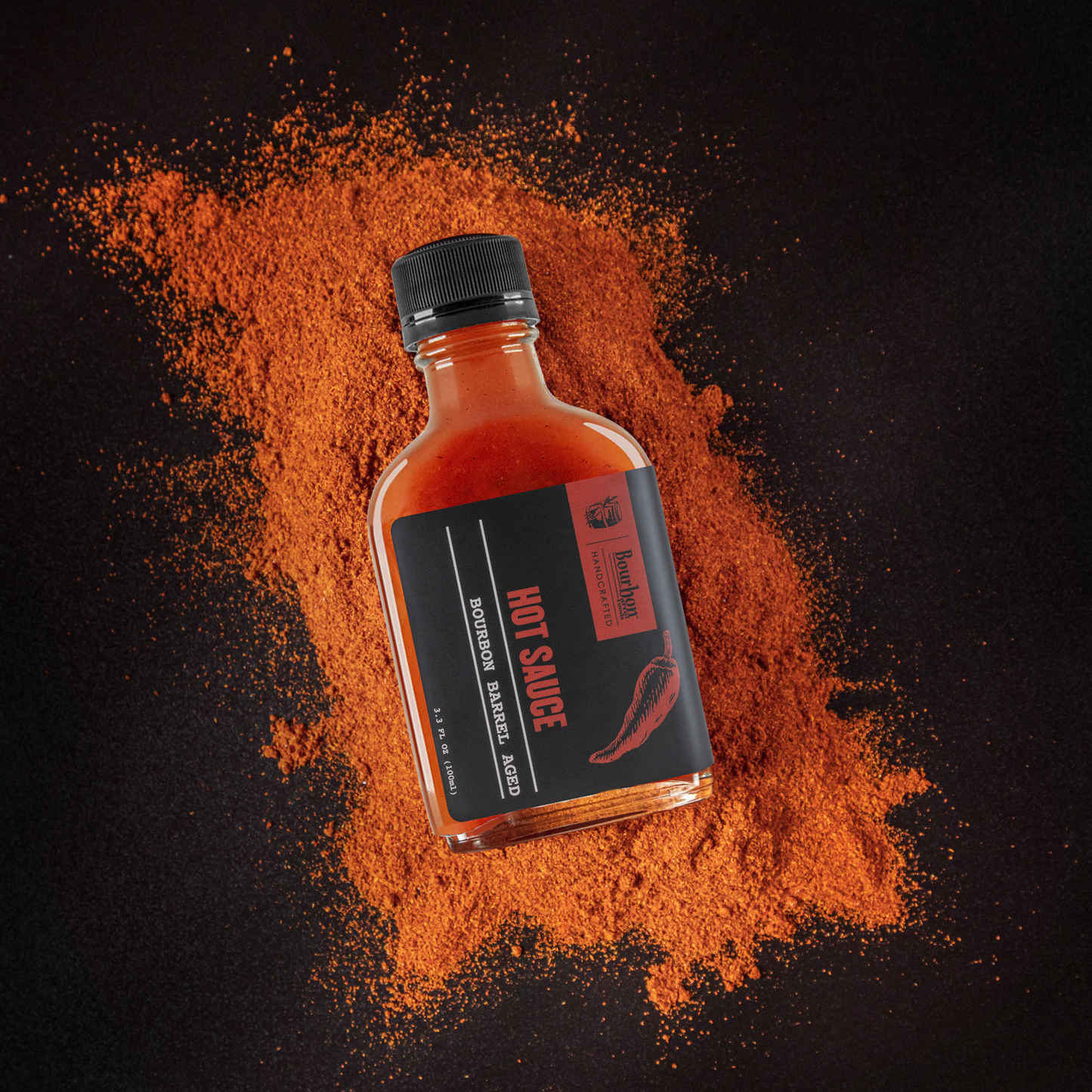 Hot sauce bottle with red liquid, black label, and chili powder scatter