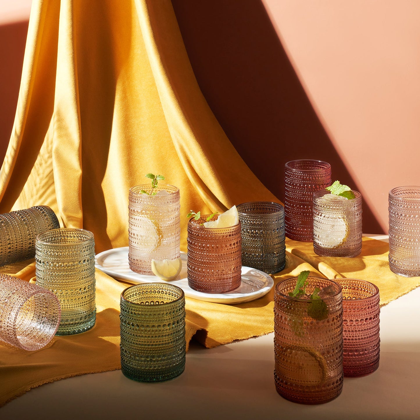 Hobnail glass tumblers set of 12 in assorted tones, several filled with fruit drinks
