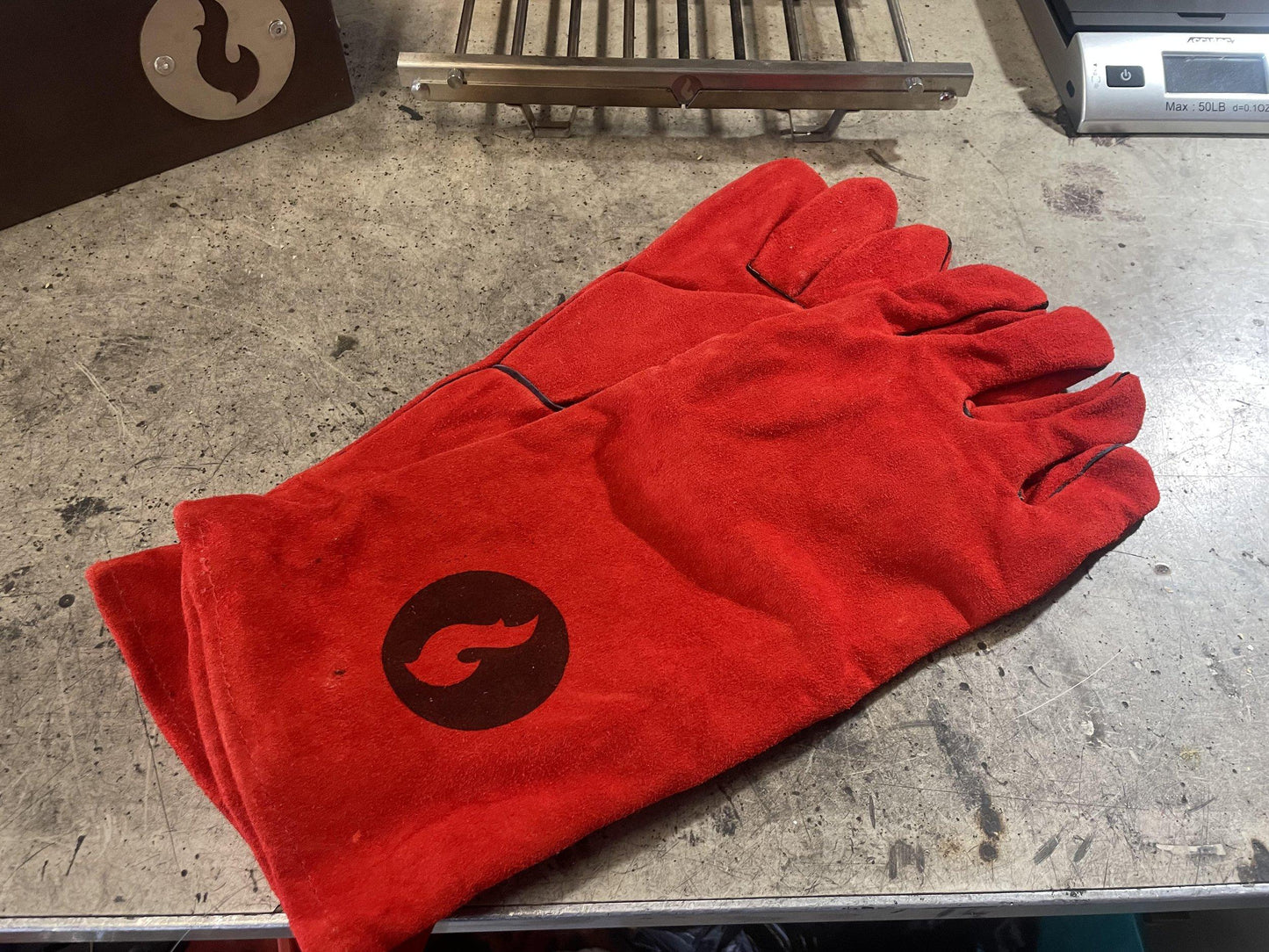 Red heat-resistant campfire gloves with flame logo, pair