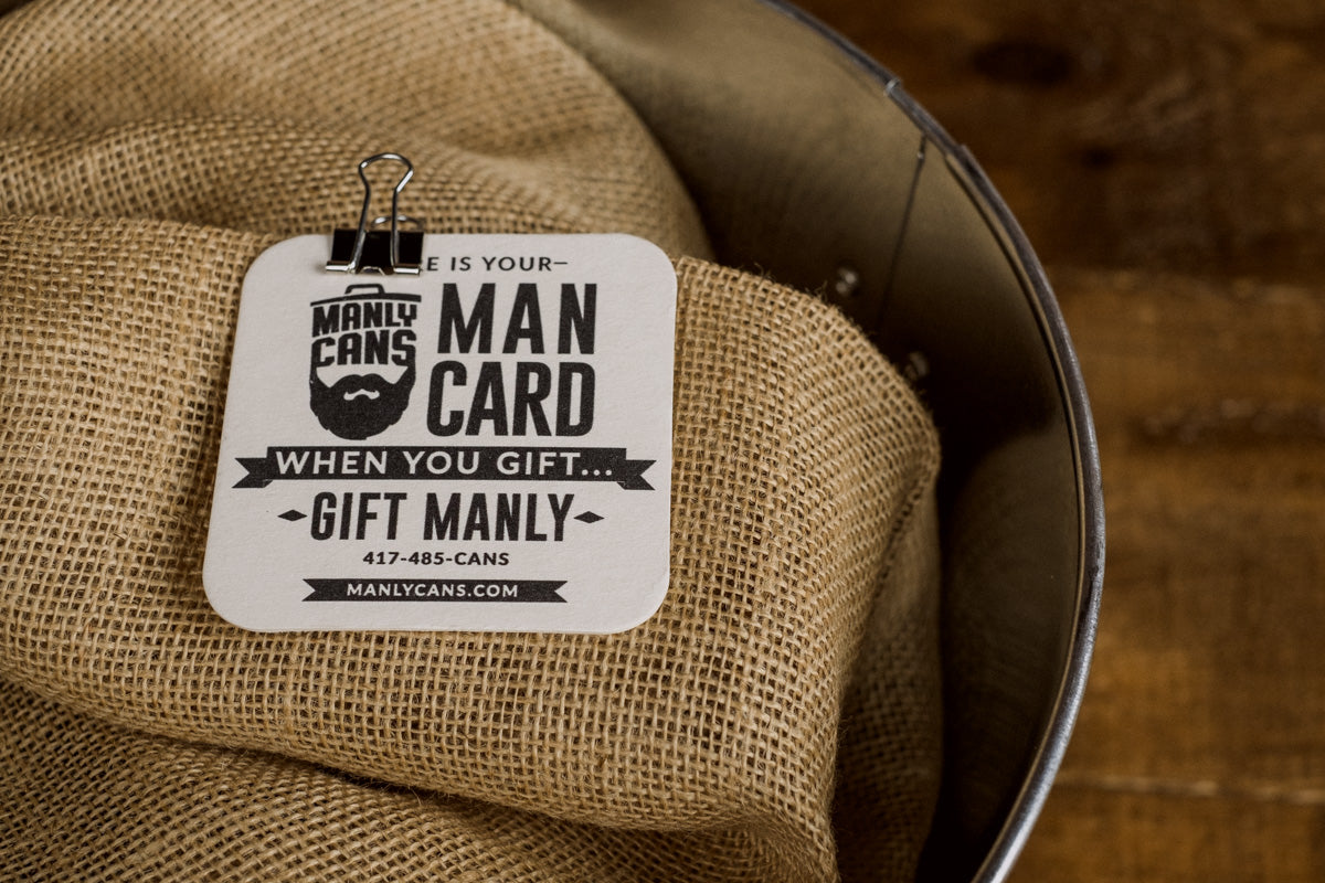 Man Card gift tag with text “MAN CARD” and “When you gift… gift manly” clipped on burlap.