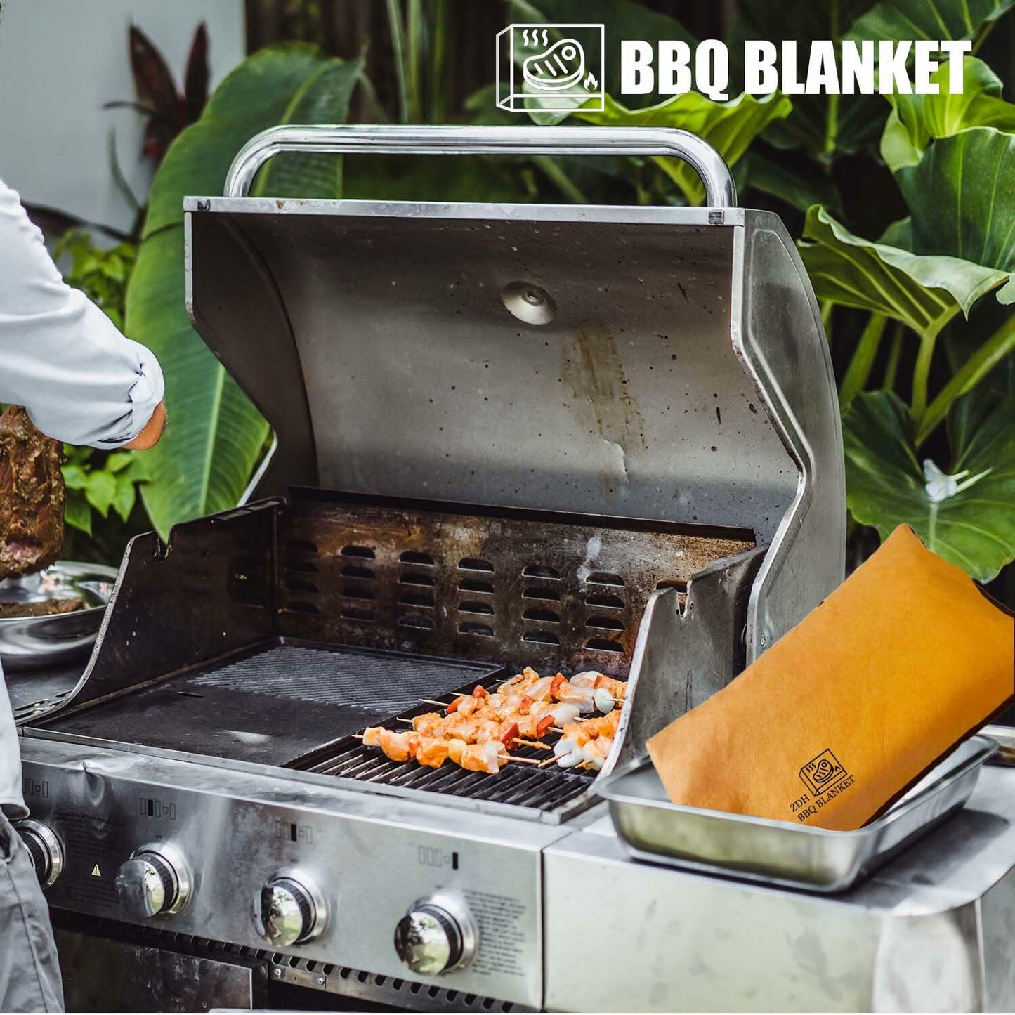 Orange BBQ blanket resting cover tucked in open grill, with brand logo