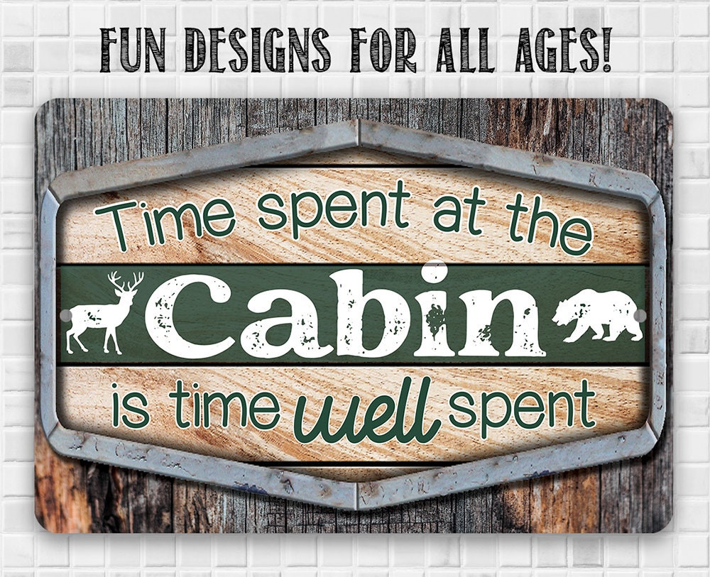 Cabin metal sign with green center, deer icons, and “Fun designs for all ages!”