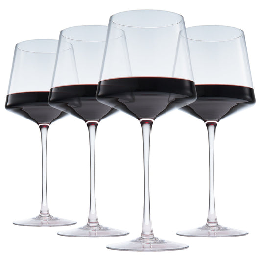 Set of four stemmed wine glasses filled with dark red wine