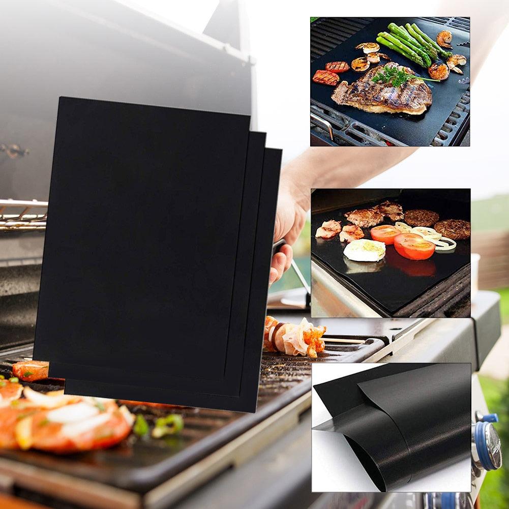 Stacked black non-stick grill mats beside a BBQ grill surface