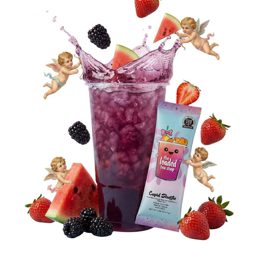 Purple iced tea cup with fruit splash and a strawberry watermelon garnish; tea stick pack nearby