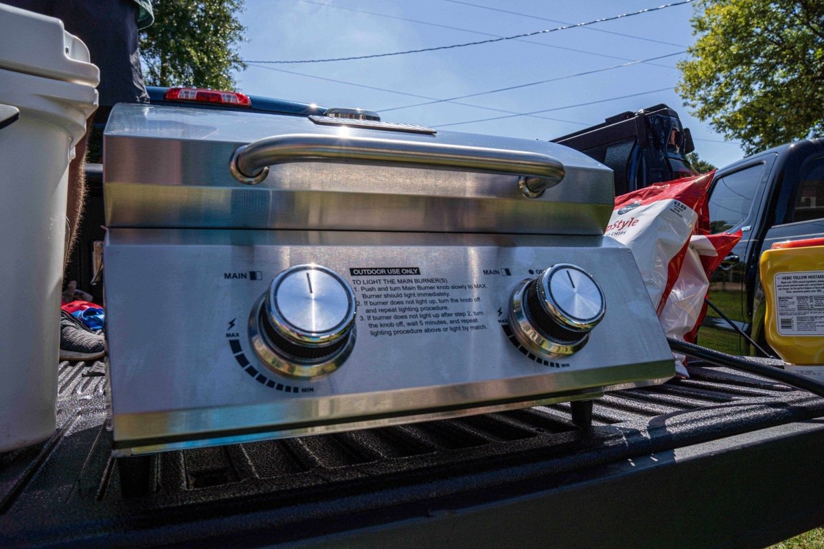 Stainless tabletop propane gas grill with open lid and two control knobs