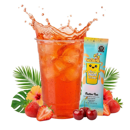 Loaded tea drink in a clear cup with ice, next to a cherry-strawberry tea stick packet.
