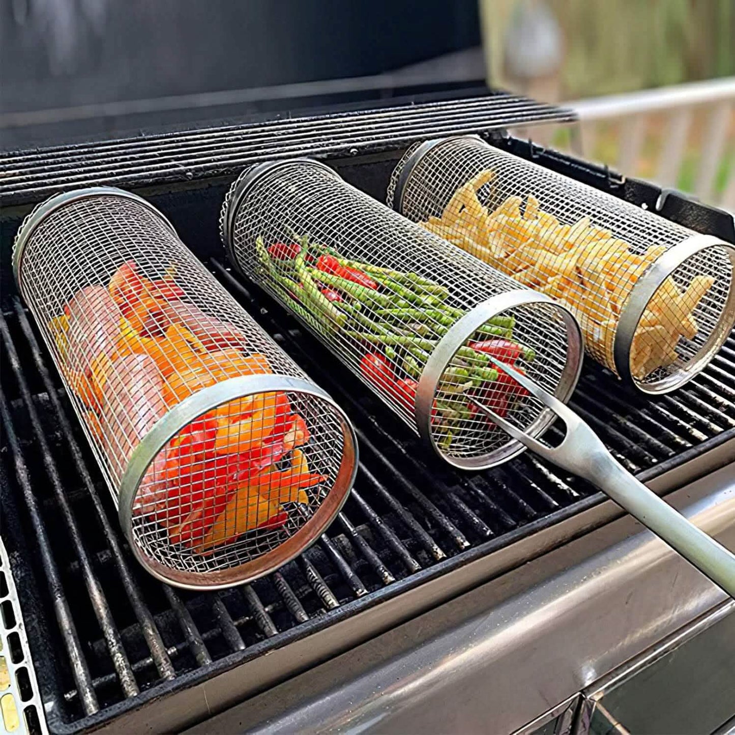 Two round mesh grill baskets with long handles on hot barbecue grates