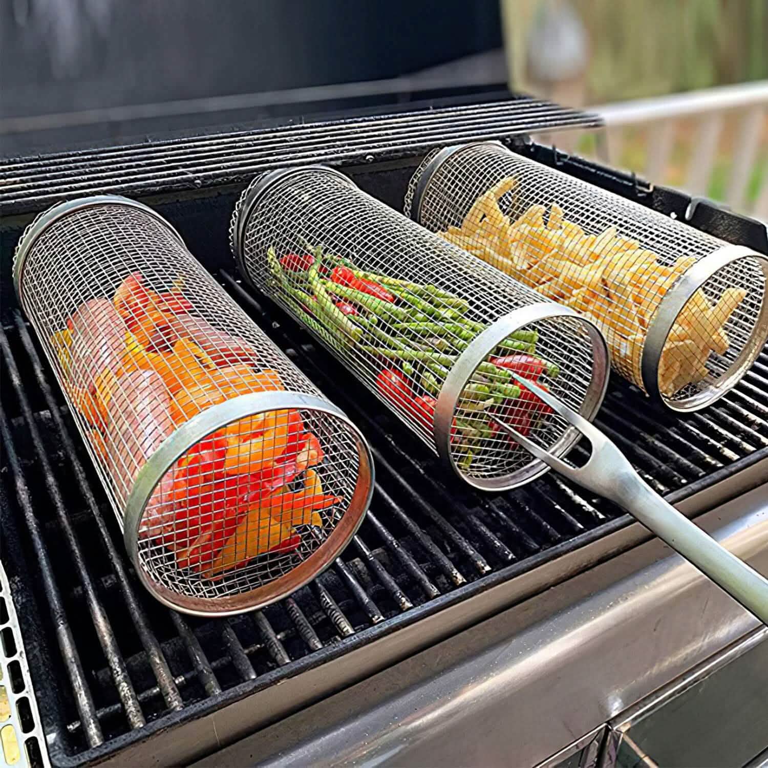 Two round mesh grill baskets with long handles on hot barbecue grates