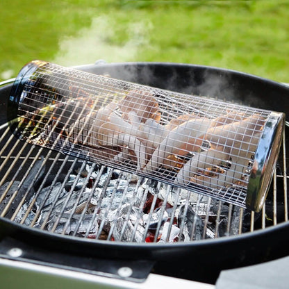 Round wire BBQ grill basket with food inside rolling over grill grates