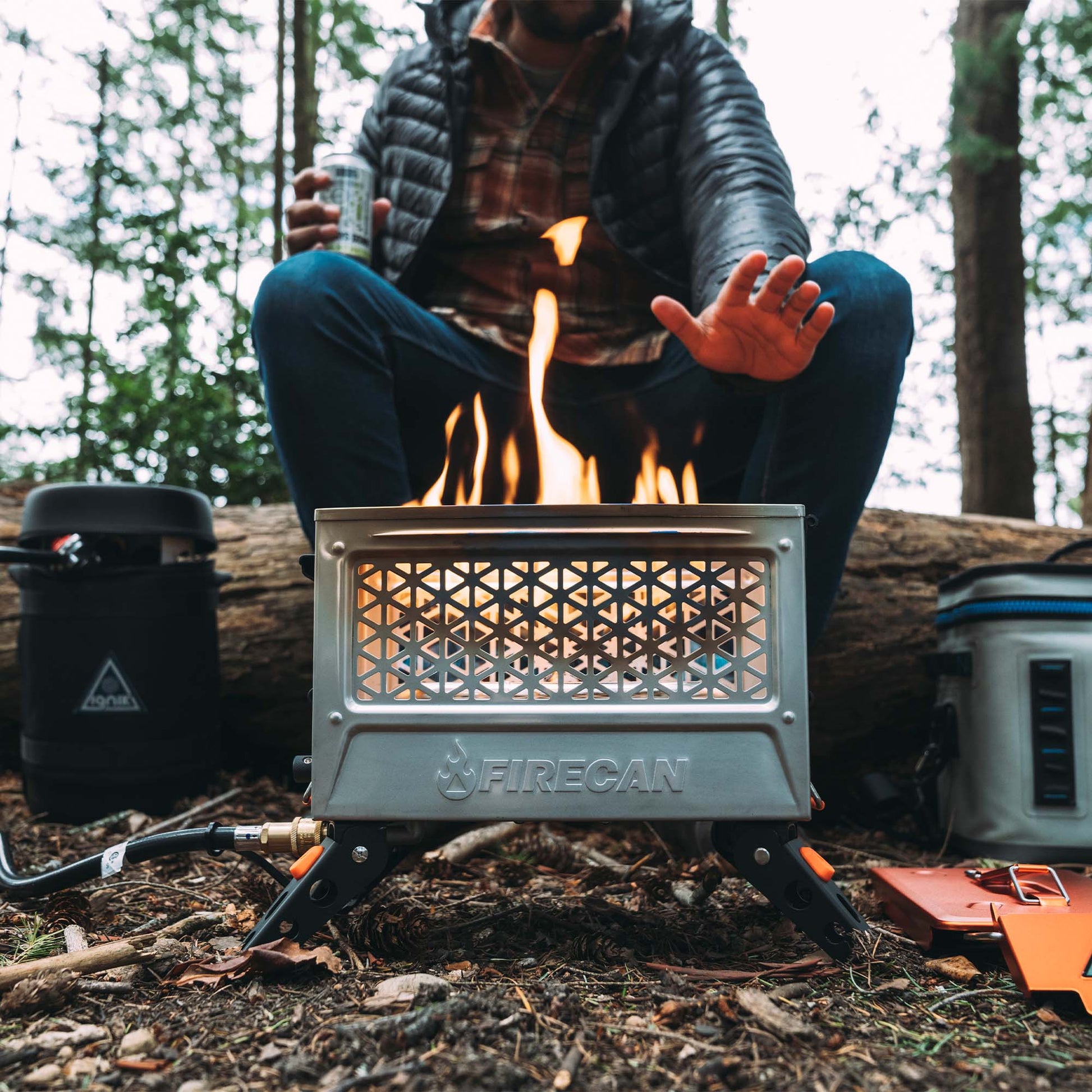 FireCan Elite fire pit with flames inside vented front mesh grate on campsite