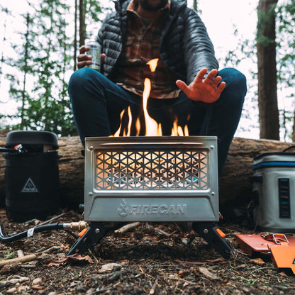 FireCan Elite fire pit with flames inside vented front mesh grate on campsite