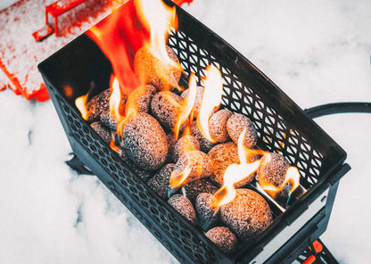 FireCan rocks in black fire pit basket with flames and glowing stones