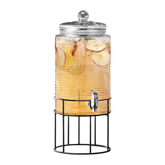 Glass beverage dispenser with metal stand, spigot, and lemons and herbs inside
