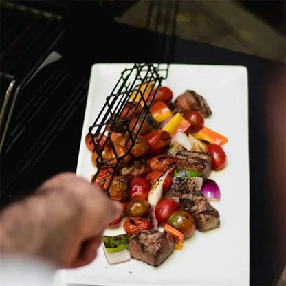 Nonstick stainless steel BBQ grilling basket over grilled vegetables and meat