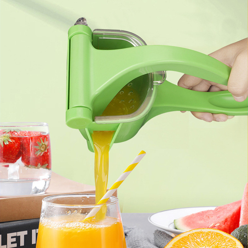 Green manual citrus squeezer with juice catcher and pouring spout into glass