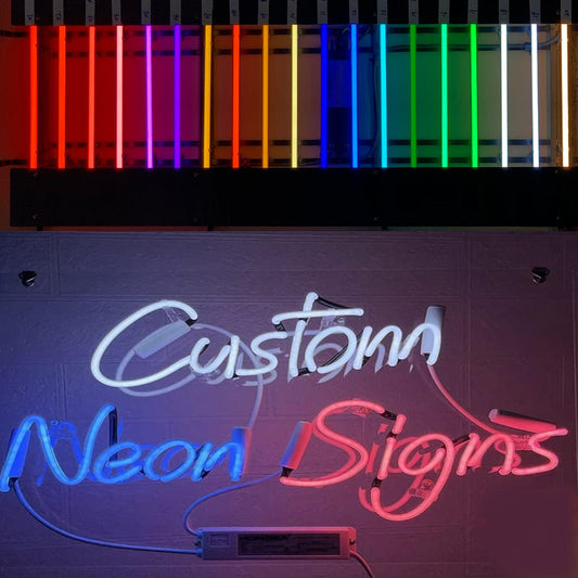 Neon sign with 'Custom' in white cursive and 'Neon Signs' in blue and pink