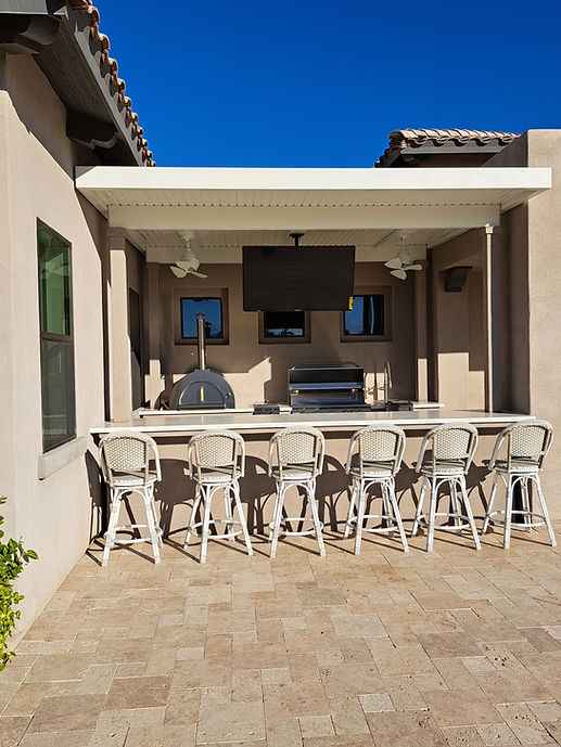 Outdoor kitchen pizza oven built into countertop with front opening and side grill