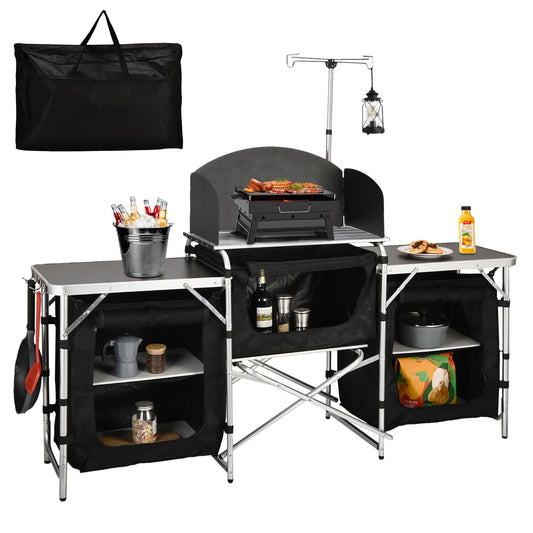 Folding camping kitchen station with black storage panels, shelves, and built-in grill table