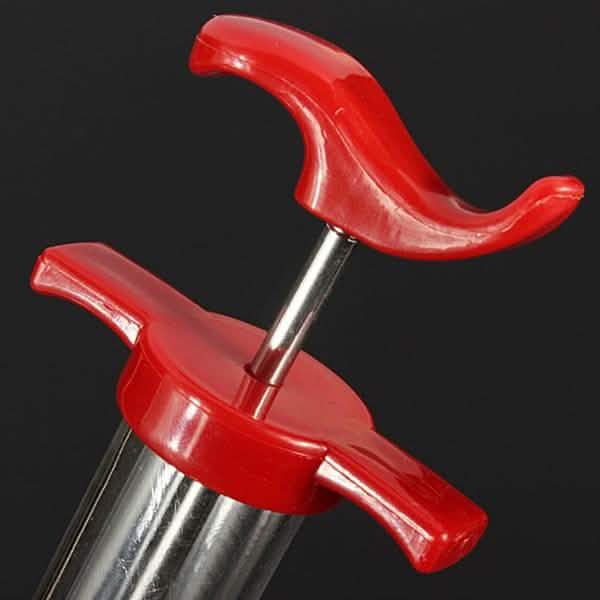 Marinade injector syringe end with red grips and clear barrel housing
