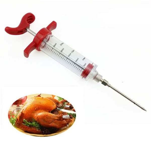 Marinade injector syringe with red wings, clear barrel and pointed metal needle