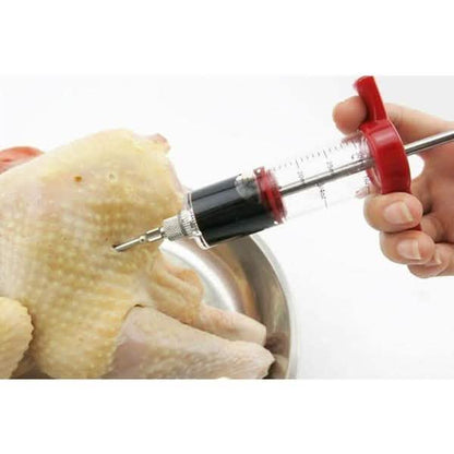 BBQ marinade injector syringe inserting into raw chicken on a metal tray