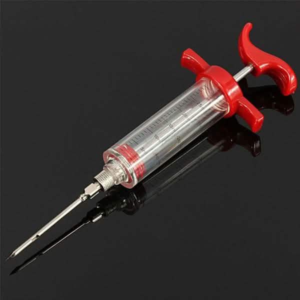Marinade injector syringe with red clamp arms, clear barrel and two metal needles