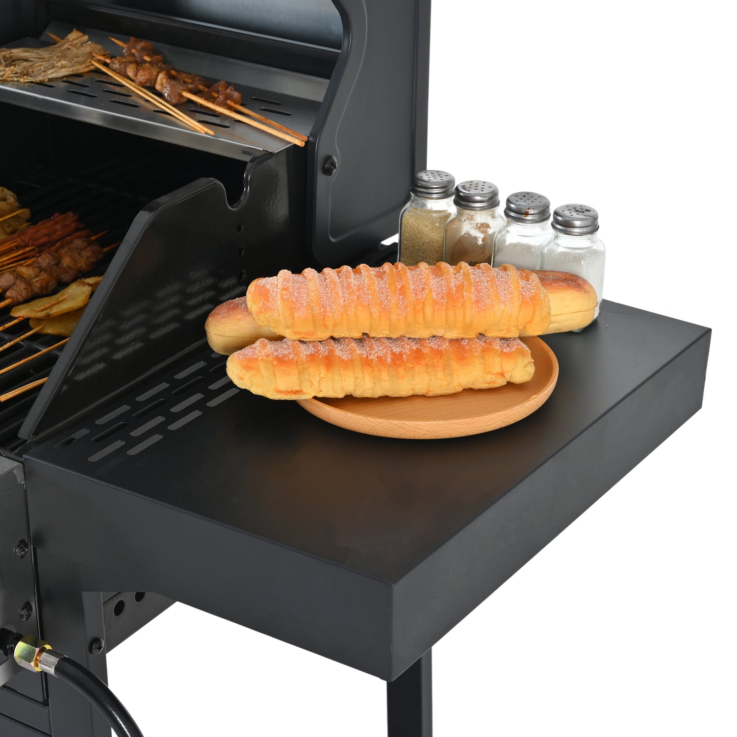 Black grill griddle surface with bread and grilled items near open cooking lid