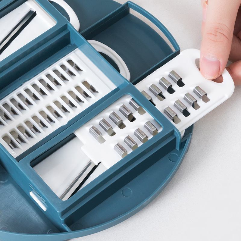 Teal salad chopper bowl with removable grater and slicing blades, open