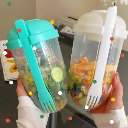 Teal and white salad shaker cups with dressing containers and built-in forks, held upright.