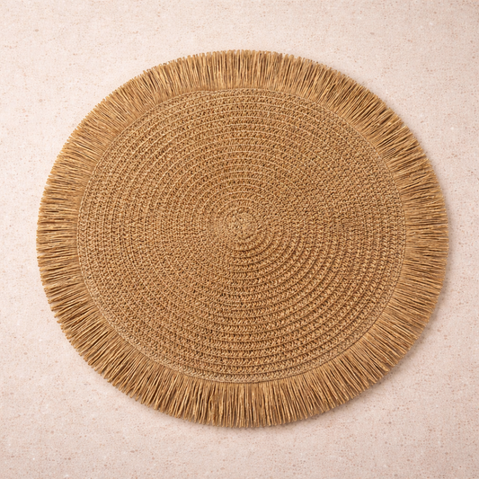 Round woven straw placemat with tan fringe and spiral weave center