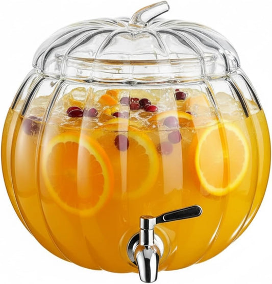 Pumpkin-shaped glass drink dispenser with spigot and clear lid, filled with orange beverage