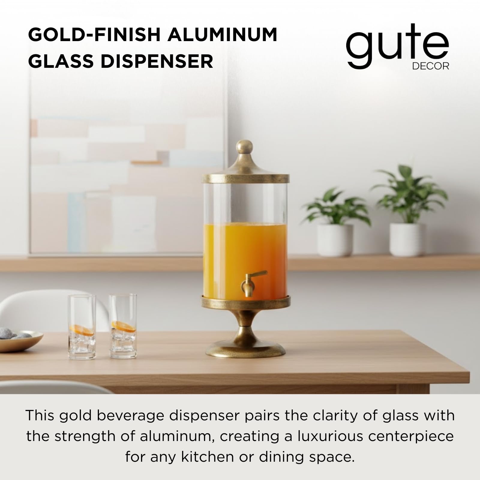 Gold beverage dispenser with clear glass cylinder and gold spigot, holding orange drink