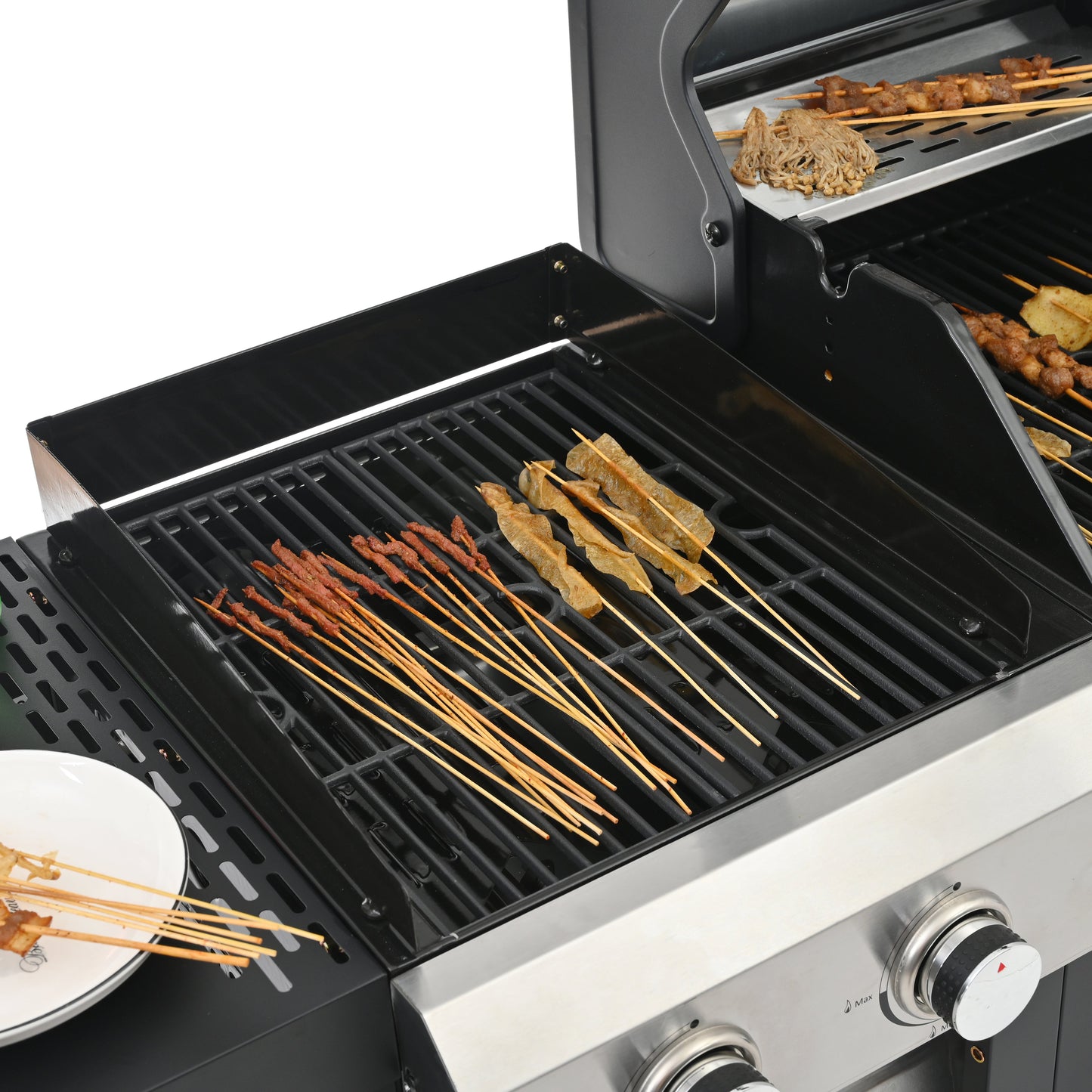 Black grill grates with grilling skewers, stainless front panel and control knobs