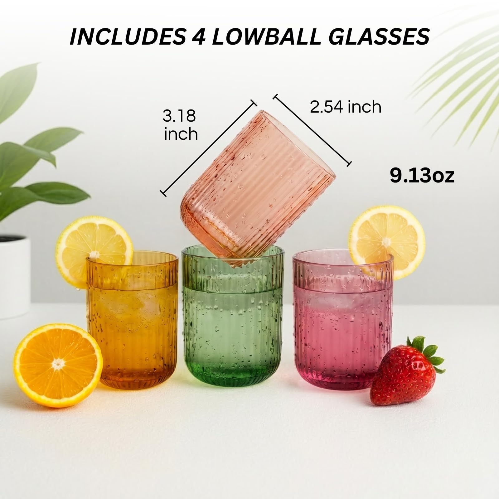 Four lowball ribbed glasses in amber, green, and pink with lemon and strawberry garnish