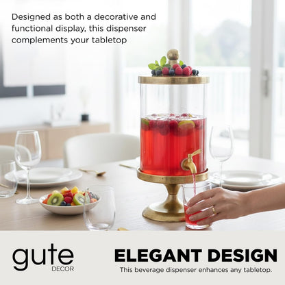 Gold beverage dispenser with clear glass cylinder, gold lid, and spigot, filled with red drink