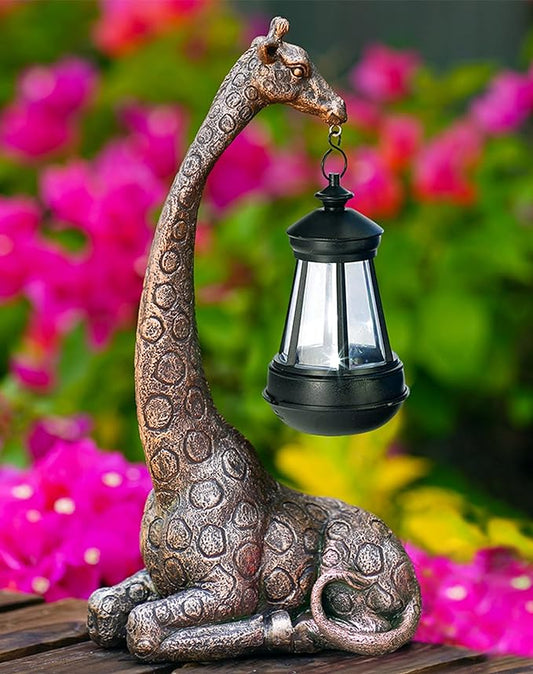 Bronze giraffe garden statue holding a black solar lantern with a glowing light