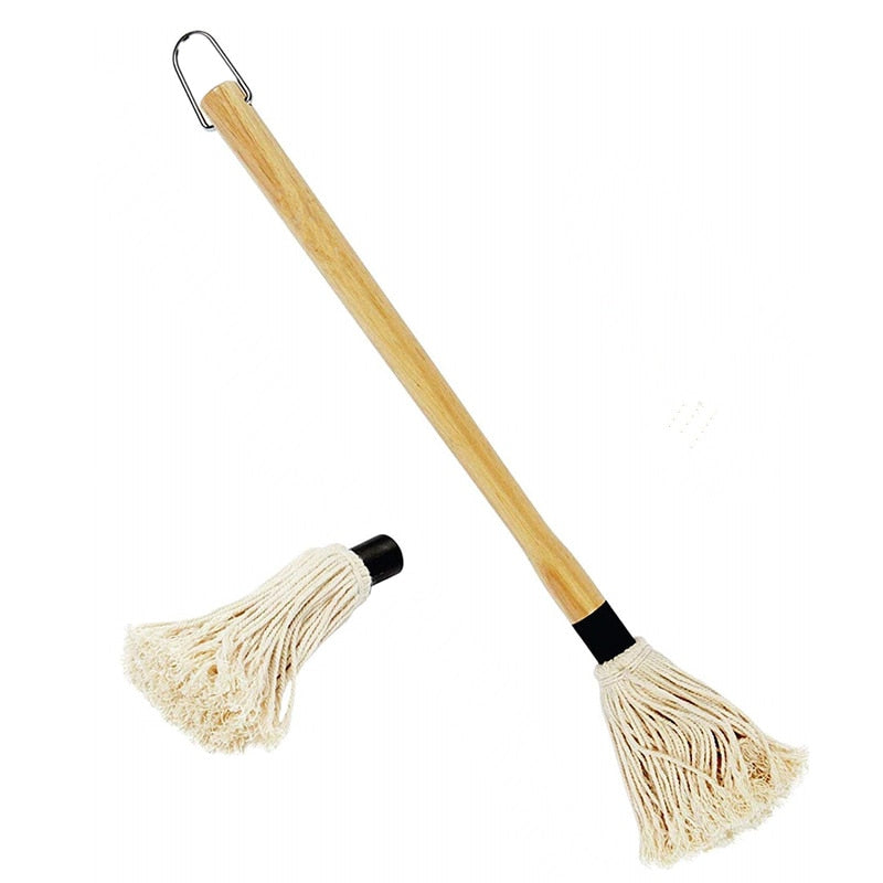 Grilling mop brush with cotton fringe head and black connector cap on a short handle