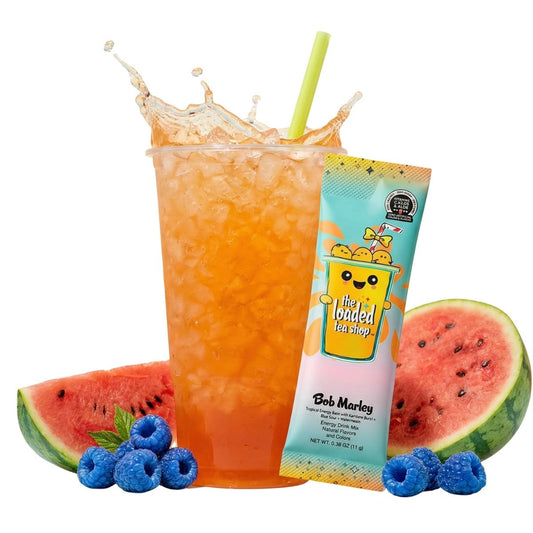 Loaded tea drink in a clear cup with straw, plus foil tea stick and fruit toppings