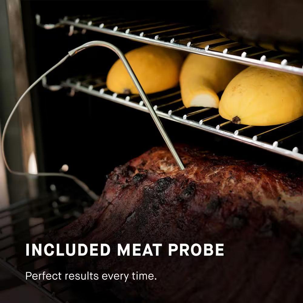Smoker cooking chamber with meat probe in seasoned meat on wire racks