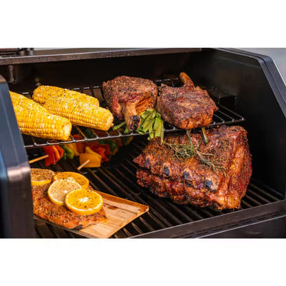 Open grill with roasted chicken, corn on the cob, and vegetables on grates