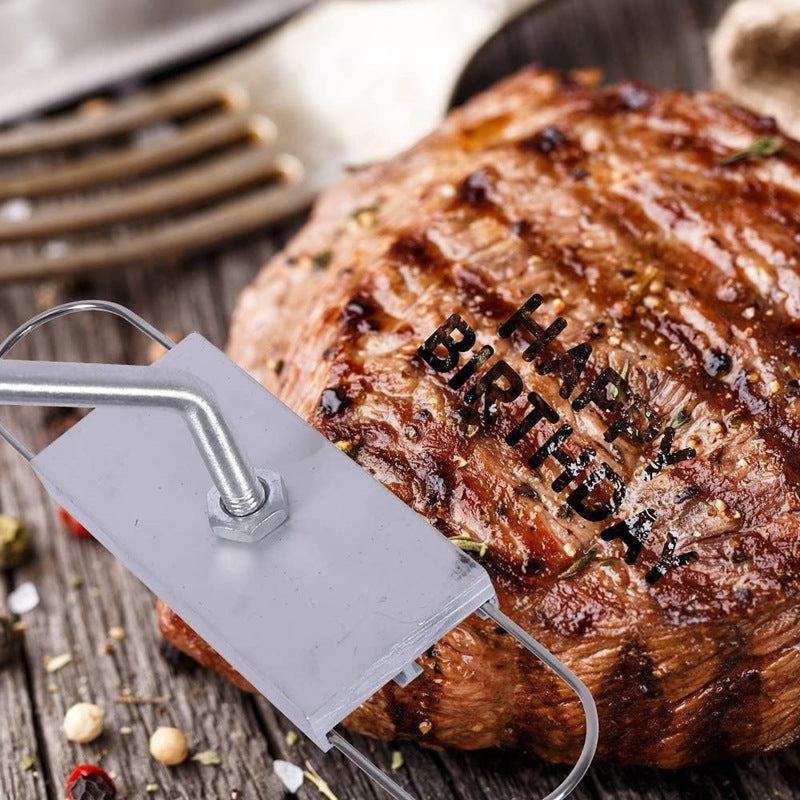 BBQ branding iron stamping letters onto a grilled meat surface