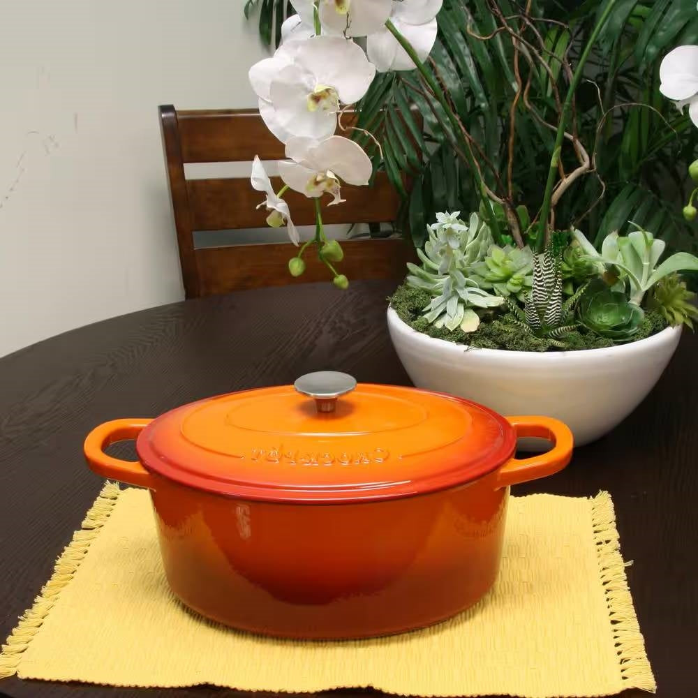 Orange enameled cast iron Dutch oven with domed lid, round knob, and side handles