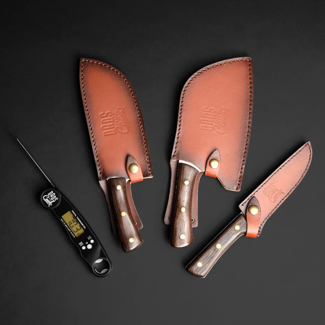 Leather knife sheaths with wood handles for a BBQ knife kit; thermometer tool shown